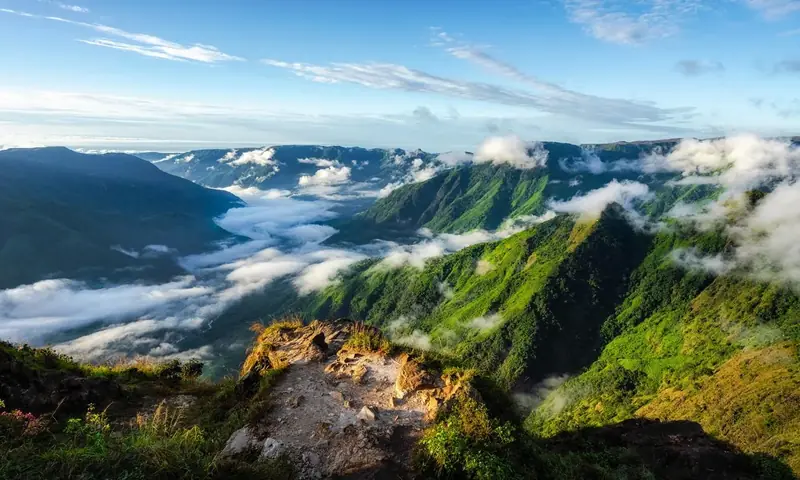 Green hill ridges above low cloud.